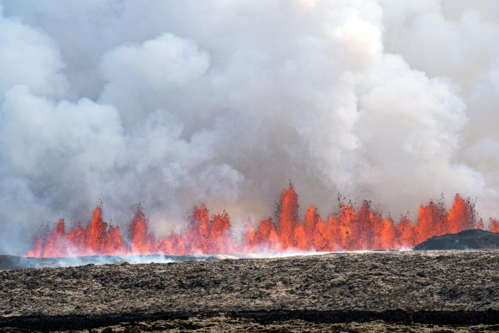 Lava spruter opp av bakken ved Grindavik. Onsdag kveld opplyser islandske myndigheter at utbruddet har dempet seg noe i intensitet.