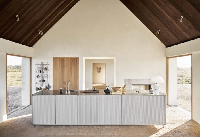 Aluminum kitchen in front of window with views over dunes.