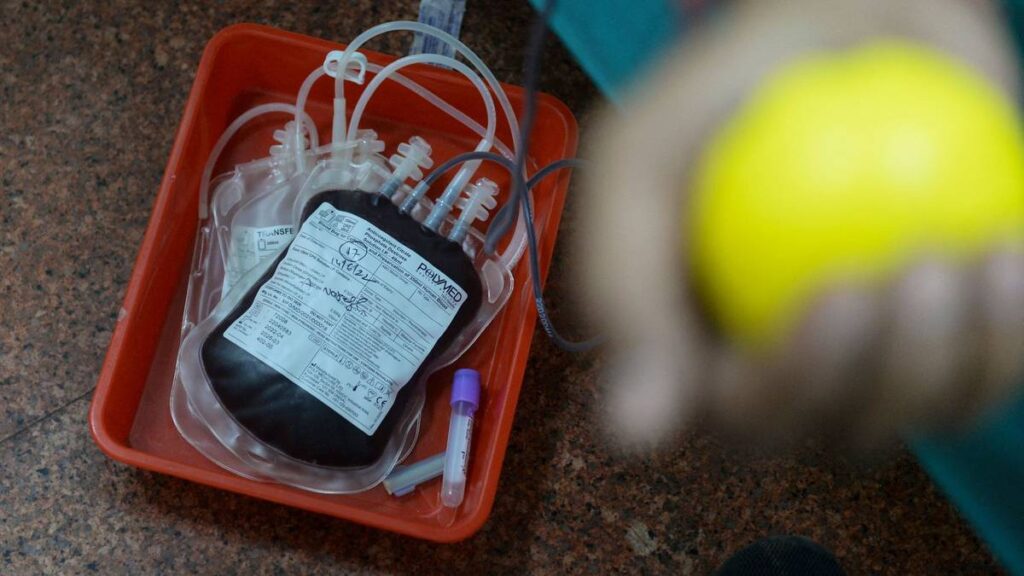 Dette bildet viser en pose med blod og en uklar hånd med en stressball i forgrunnene. Det er posen med donert blod som er i fokus. Det er en politimann som gir blod på World Blood Donor Day i Hyderabad i India 14. juni 2022.