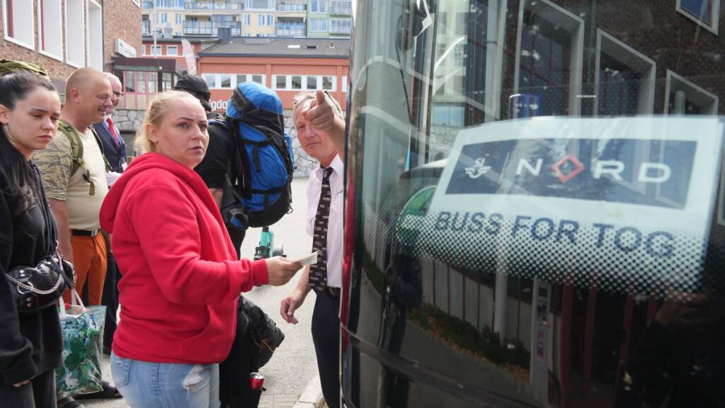 Buss for tog til Trondheim. Passasjerer står i kø utenfor en buss ved jernbanestasjonen i Bodø.