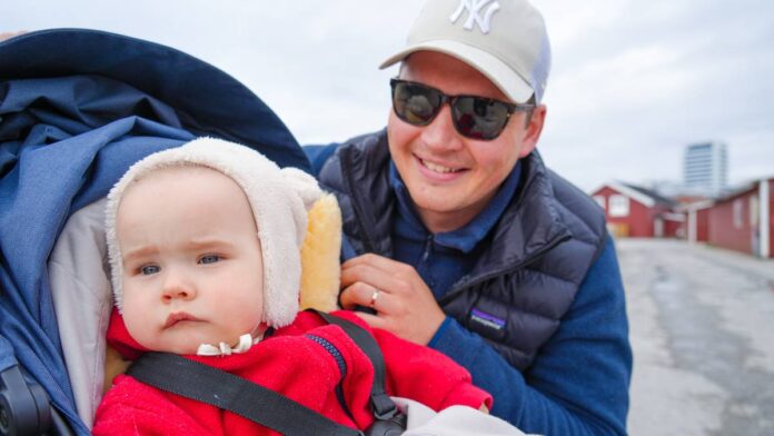 Emma (1 år) og pappa Henrik Mjelva går på søndagstur på moloen i Bodø. Pappa har blå genser, blå boblefest, grå caps og solbriller. Emma har hvit fleacelue og rød fleacegenser og sitter i en barnestol.