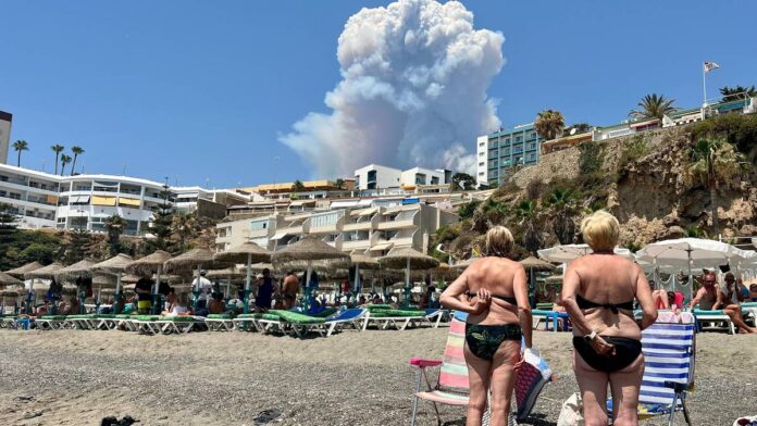 Turister på Malaga ser på brann