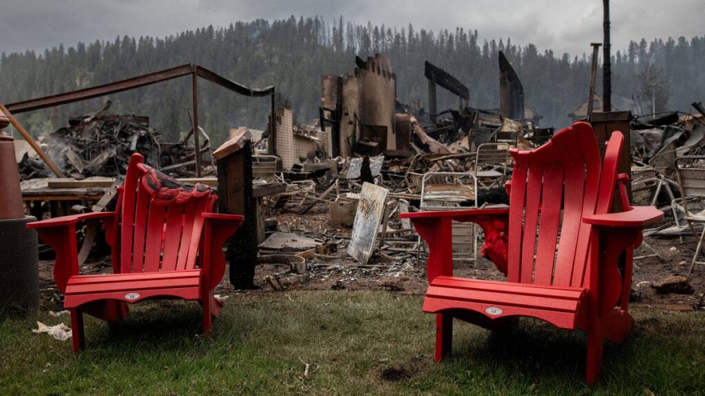 To røde plaststoler som er delvis smeltet av varme etter brannen står fremfor et hus som er helt nedbrent i byen Jasper i Canada.