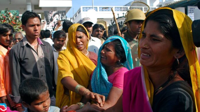 Relatives of the victims of a stampede weep in Kunda village